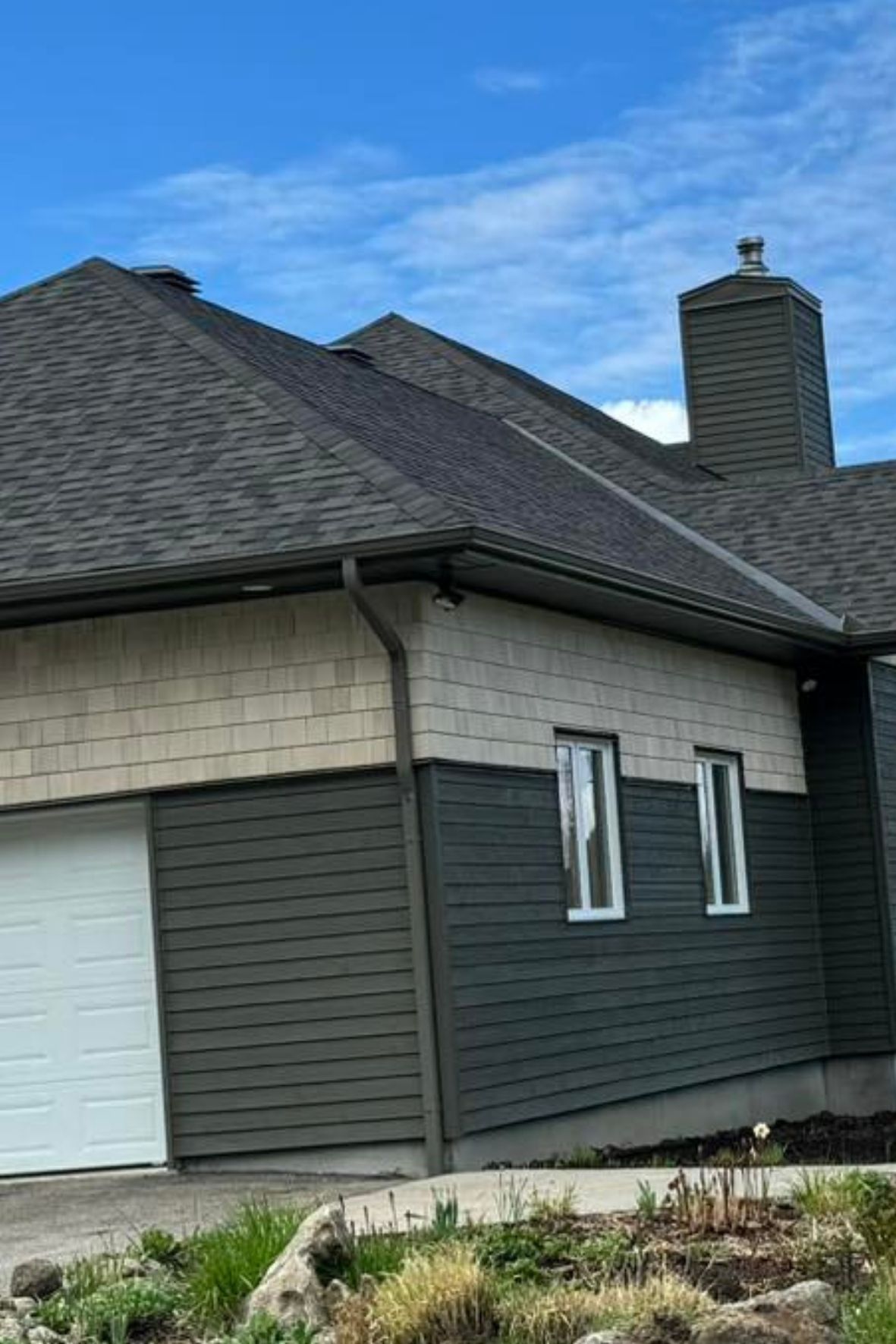 Maison avec toiture en bardeaux, gouttières et revêtement extérieur visibles sur façade au Québec