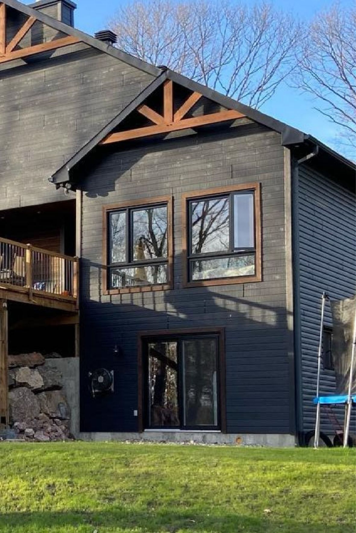 âtiment résidentiel avec revêtement extérieur sombre et structure de toiture apparente au Québec