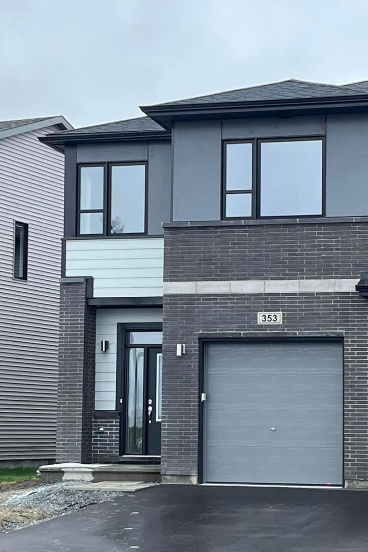 Façade de maison moderne avec revêtement mixte et garage intégré au Québec