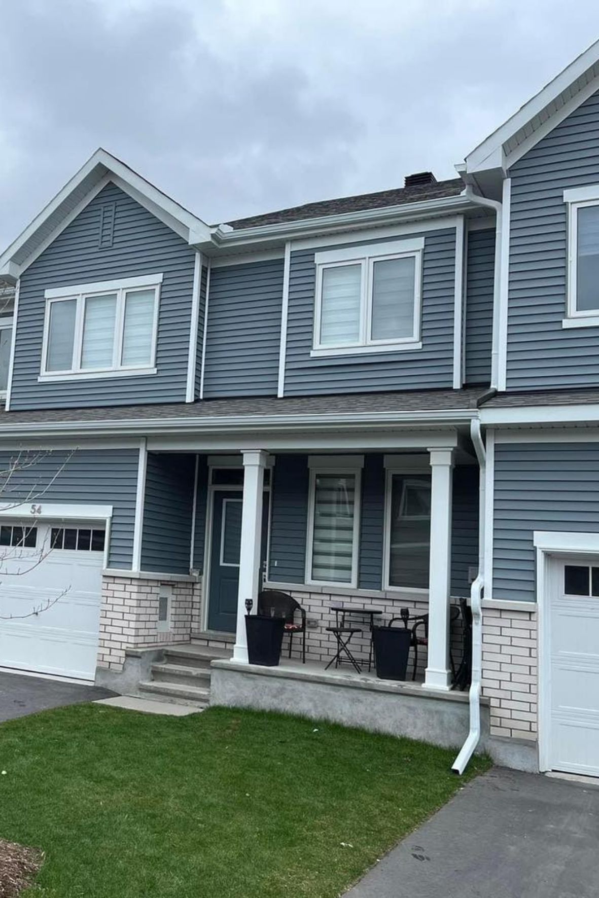 Maison jumelée avec revêtement extérieur et gouttières visibles sur toiture au Québec